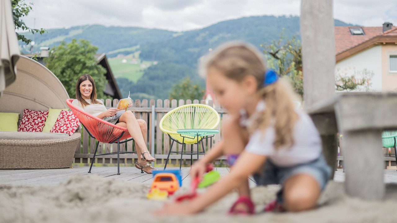 Bambina gioca sulla spiaggia con mamma parco giochi Hotel Fameli