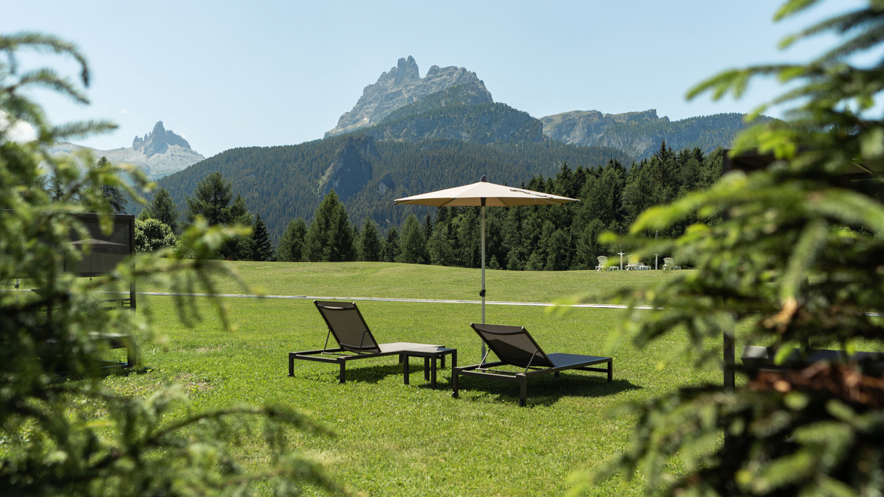Giardino con sdrai in estate Hotel Tofana Cortina