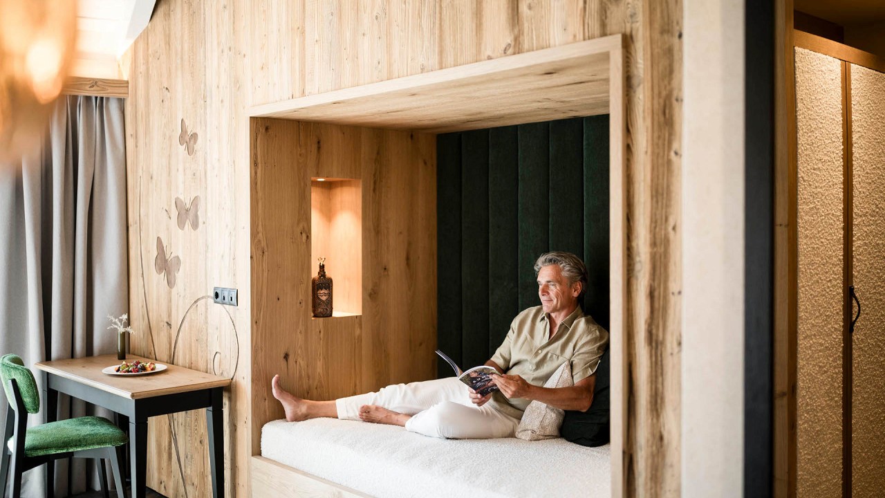 uomo legge in camera - Mirabell Dolomites Hotel Valdaora
