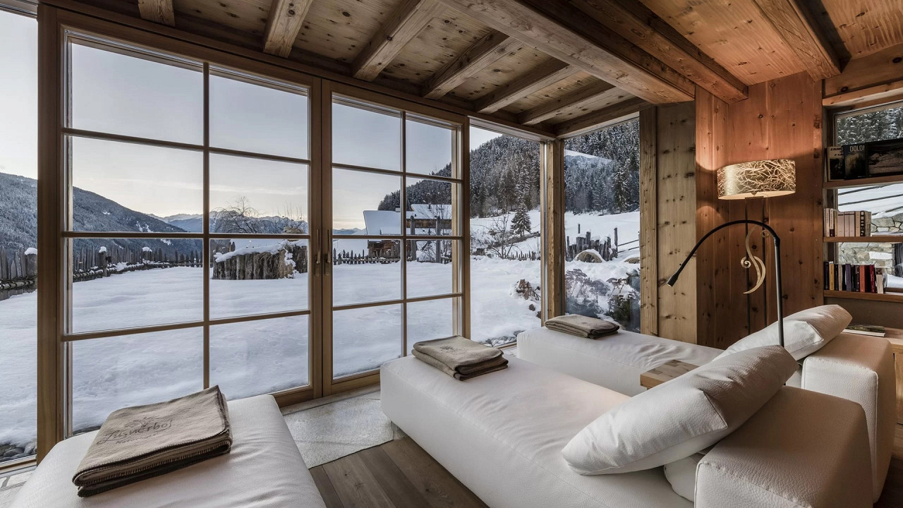 Salle de détente avec vue en hiver Naturhotel Lüsnerhof Luson