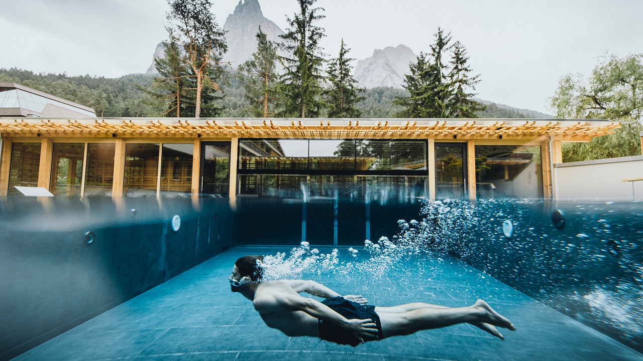 Uomo nuouta in piscina esterna Sensoria Dolomites