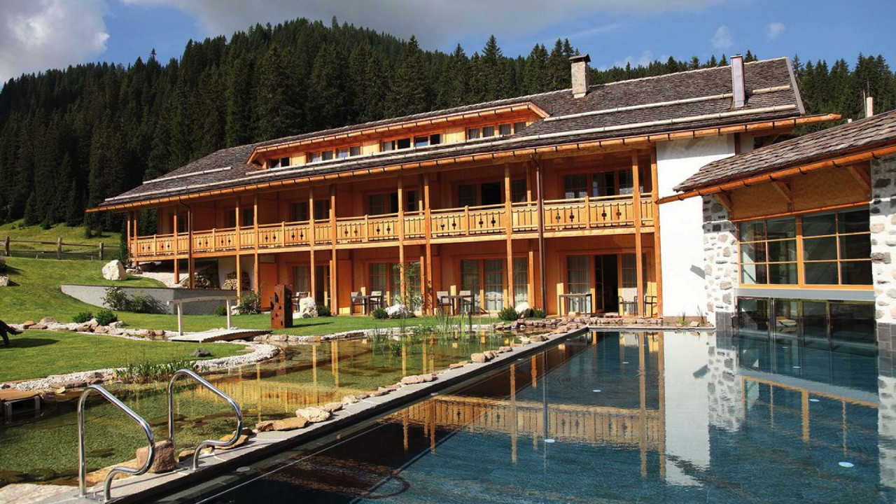 Sommerfassade mit Pool und Teich Tirler Hotel Seiser Alm
