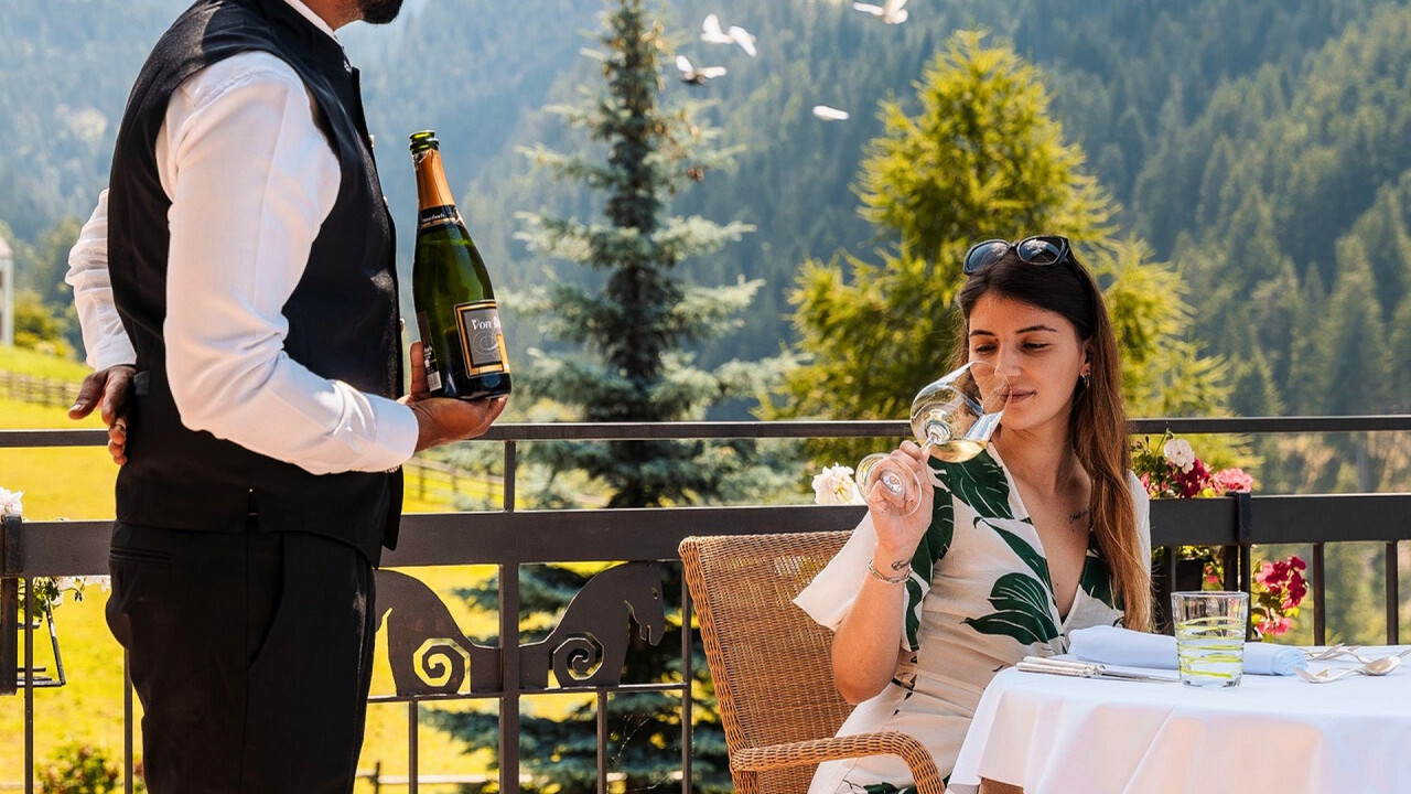 Sommelier versa vino a ragazza per degustazione Romantik Hotel Post